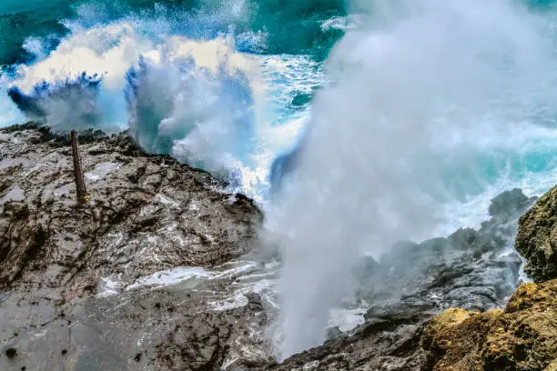 Colorful Halona Lava Blowhole Halona Point Oahu Hawaii Waves roll in rock formation shoots sea spray in the air