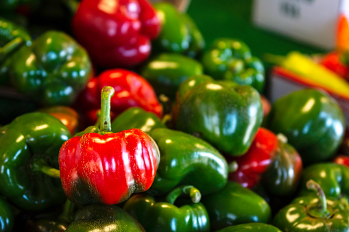 Sweet green bell peppers on display for sale at a farmers market.