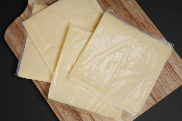 istock Transparent packet with slices of cheese on yellow , 1442669151