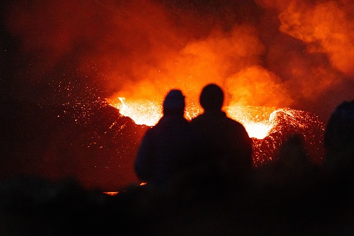 The silhouettes of people watching the glowing magma from the Meradalir Volcano Eruption in Iceland