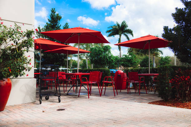 istock Outdoor cafe with red tables, chairs and umbrella 1442681415