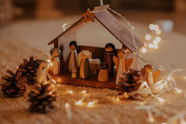 A selective focus shot of a nativity scene surrounded by Christmas lights