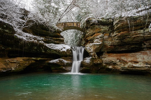 The waterfall and bridge in Hocking Hills on a snowy winter day in the USA