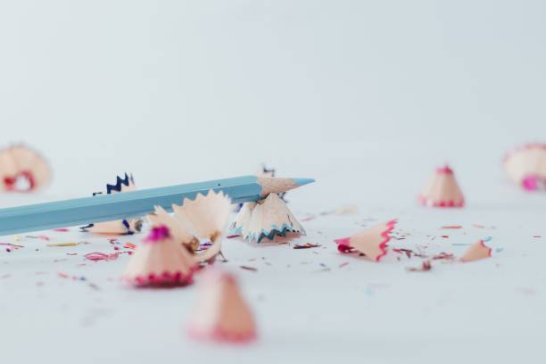 istock Closeup of a sharpened blue pencil with pencil shavings on white surface 1442685890