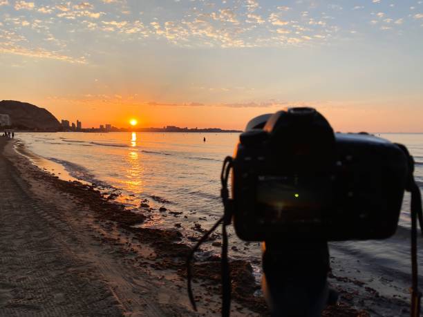 istock Professional camera on a tripod placed on a coastline shooting the sunset 1442686086
