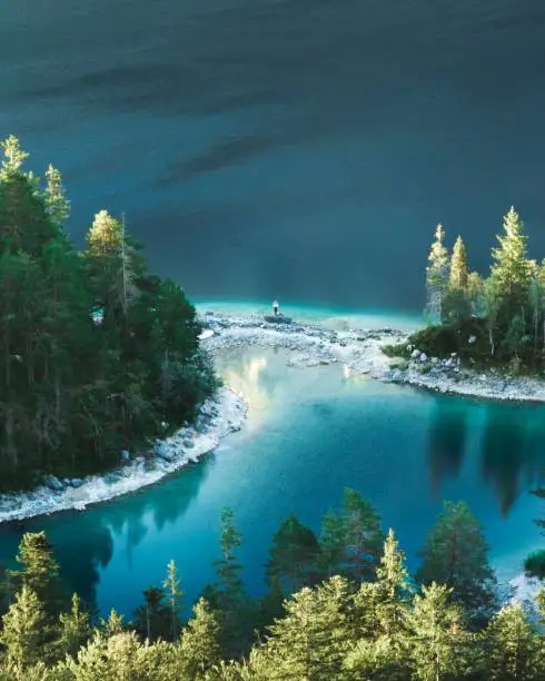 The mesmerizing aerial view of the Eibsee lake with evergreen trees in winter