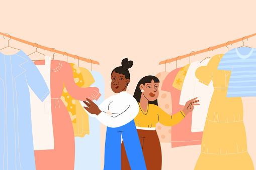 A black and Asian friend shopping for clothing together at a local thrift store