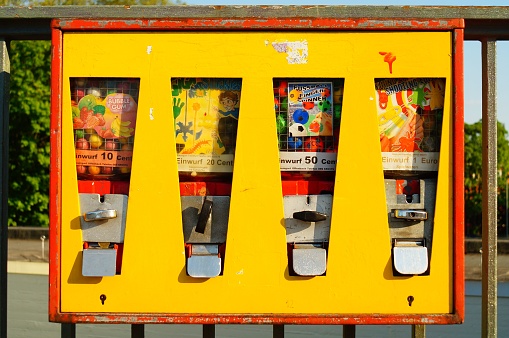 Frankfurt, Germany – May 09, 2022: An old chewing gum vending machine in Frankfurt, Germany.  In use for decades, often repainted, currency converted, still in service.