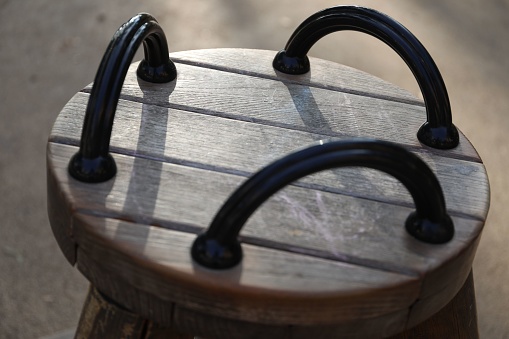 A round wooden chair with iron holders