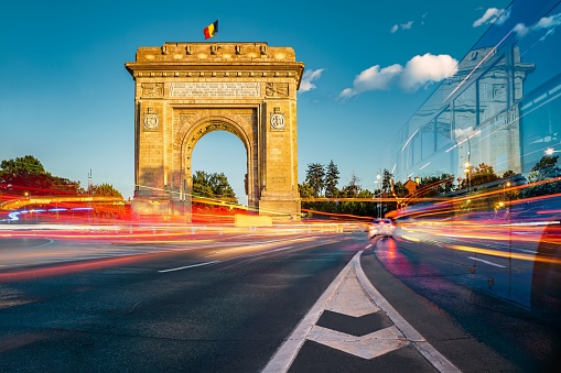Arco triunfal, hito histórico en Bucarest, Rumania con larga exposición, senderos de luz de automóviles photo