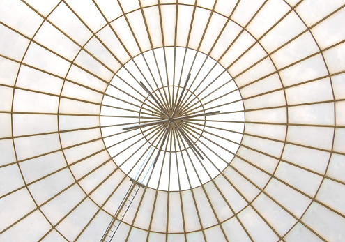 A closeup of a round glass roof inside of a building
