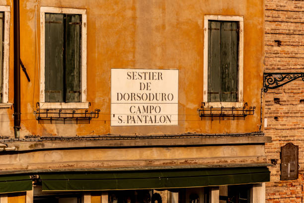 plan rapproché d’une façade d’un ancien bâtiment avec un panneau en italien à venise, italie - dorsoduro quarter photos et images de collection