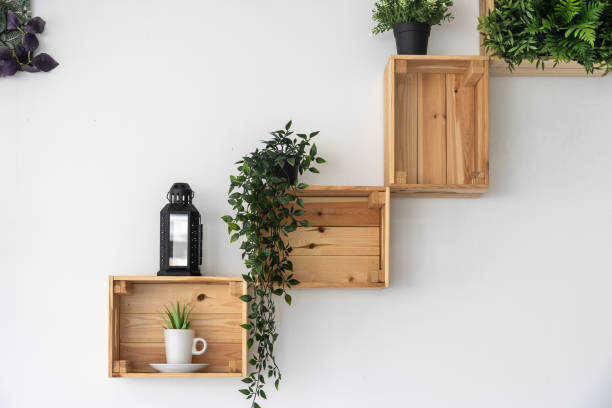 Wooden boxes fixed on the white wall as decorative racks for plants