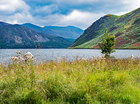 The high angle view across a loch towards a range of hills in Dumfries and Galloway, south west Scotland.\nThe fresh water reservoir is part of the Galloway Hydro Electric Power scheme.