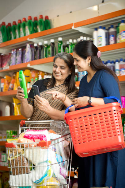 istock Shocked mother and daughter using phone at store 1442698561