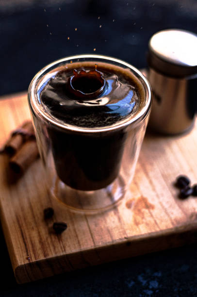 istock Double espresso coffee mug with cinnamon sticks and coffee beans on a wooden board 1442699839