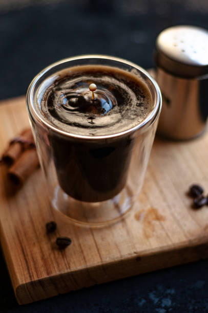 istock Double espresso coffee mug with cinnamon sticks and coffee beans on a wooden board 1442700109
