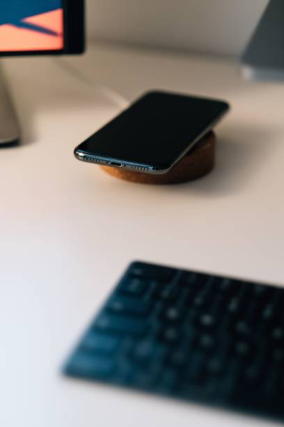 istock Phone being charged on a wireless charging device 1442703938