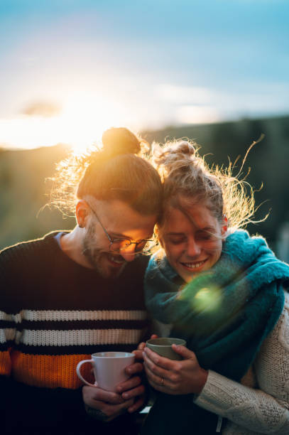 istock Young couple drinking coffee or tea while standing on their balcony at sunrise 1442706011