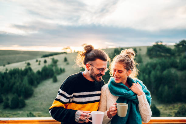 istock Young couple drinking coffee or tea while standing on their balcony at sunrise 1442706012