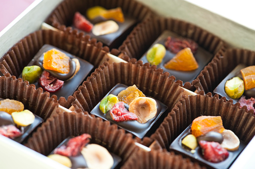 close up of box of chocolates, christmas chocolate with dried berries and nuts, traditional french christmas dessert