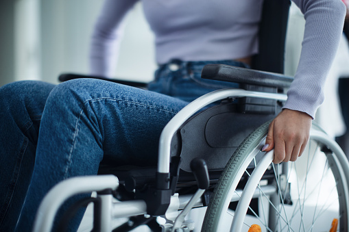 Close-up of young woman at wheelchair in a hospital.