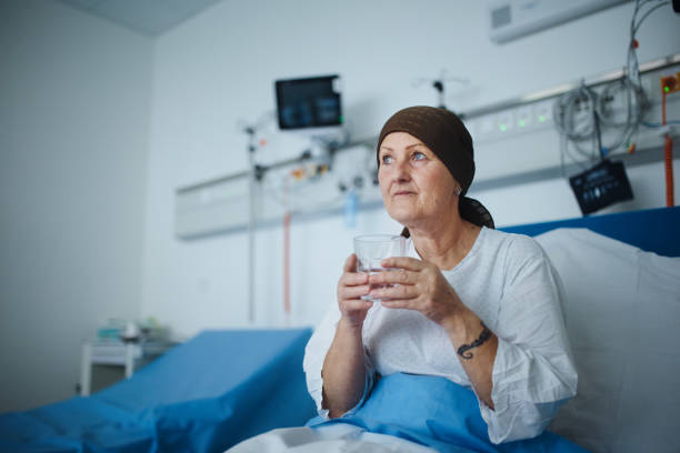 Senior woman sitting in hospital room after chemotherapy. stock photo