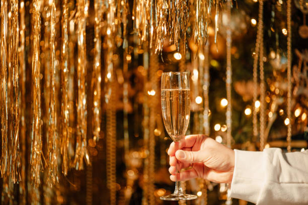 verre de champagne dans la main de l’homme contre luxe lueur dorée décoration pluie chère fête de vacances - polish bread photos et images de collection