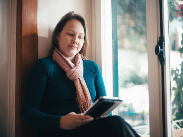 istock Woman reading electronic book in her house. 1442715903