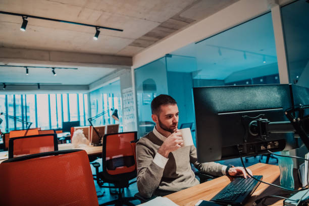 istock Modern Office: Portrait of Stylish Businessman Works on Computer, Does Data Analysis and Creative Designer, Looks at Camera and Smiles. Digital Entrepreneur Works on e-Commerce Startup Project 1442717450