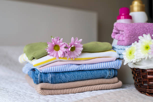 istock Stack of clean, colorful clothes and flowers on the bed 1442718711