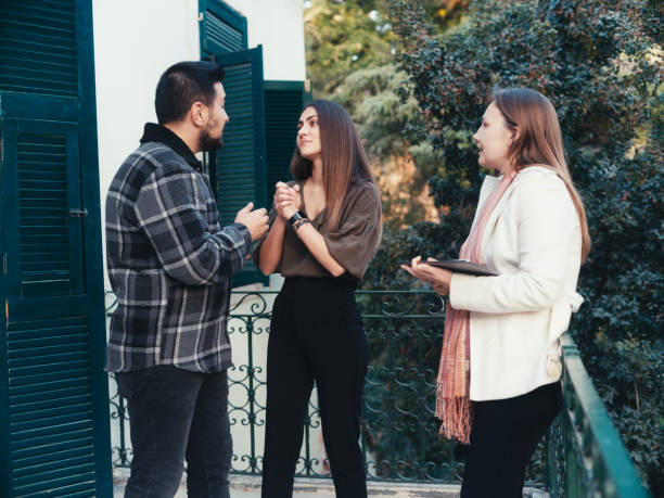 agente imobiliário com um jovem casal em uma nova casa - mansion real people candid meeting - fotografias e filmes do acervo