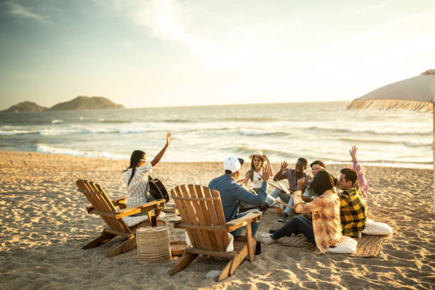 Friends having a picnic toasting marshmallows at the beach
