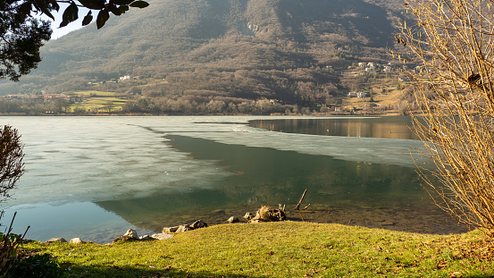 Lake Endine, Bergamo, Italy. Amazing view of the lake in winter time. Partially frozen lake. Ice covering part of the lake