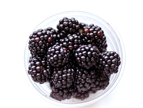 glass of blackberries seen from above on a white table