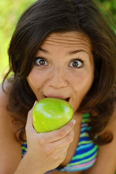 istock Beautiful young woman eating an apple 144272806