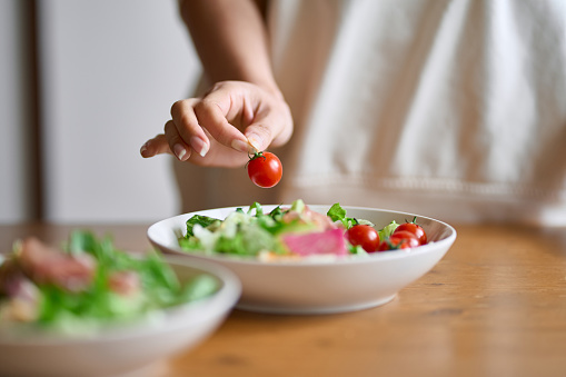 A woman's hand serving a salad