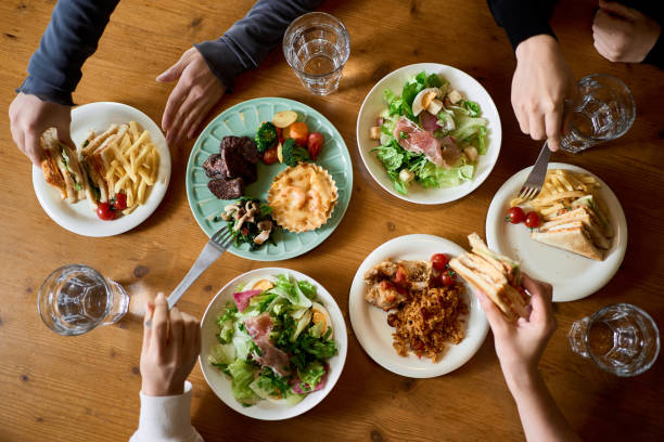 hands of women eating at a girls' association - mesa de jantar imagens e fotografias de stock