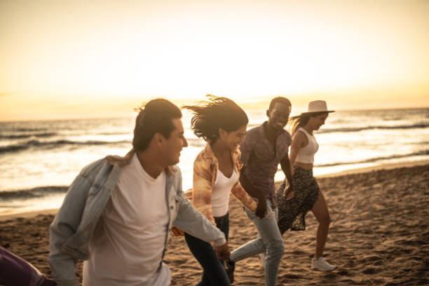 istock Friends walking holding hands at the beach 1442730935