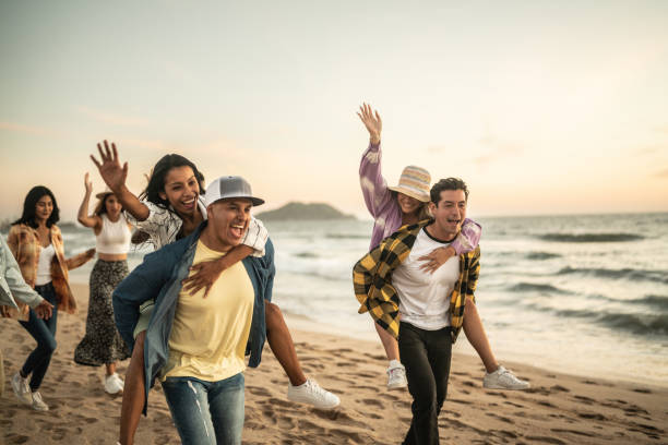 istock Friends walking and playing on the beach 1442732364