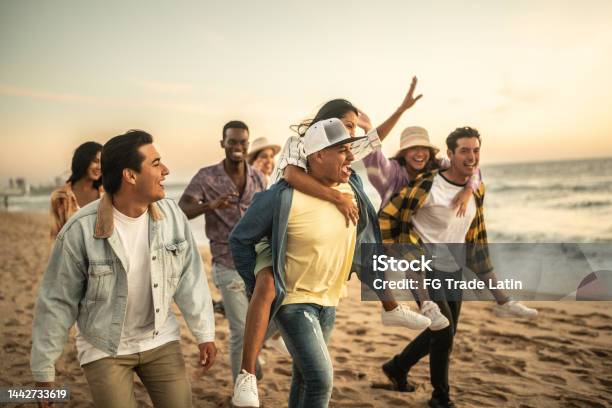 Friends Walking And Playing On The Beach Stock Photo - Download Image Now - 20-29 Years, 30-39 Years, Active Lifestyle