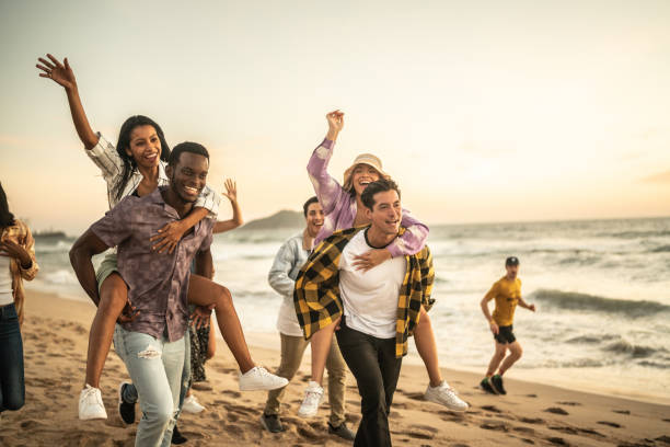 istock Friends walking and playing on the beach 1442733638