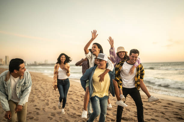 istock Friends walking and playing on the beach 1442733641