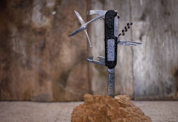 istock Swiss army knife stuck in a rock with a rustic background 1442734198