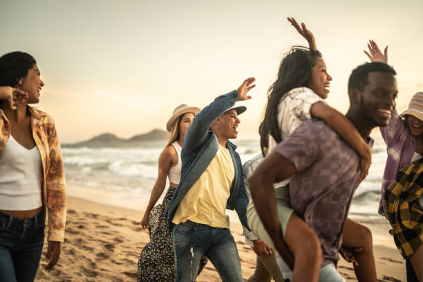 istock Friends walking and playing on the beach 1442734430