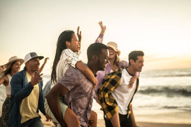 istock Friends walking and playing on the beach 1442734432