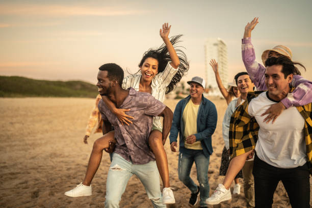 istock Friends walking and playing on the beach 1442734451