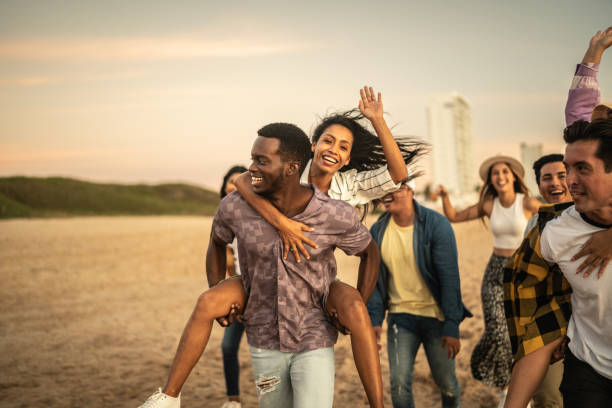 istock Friends walking and playing on the beach 1442734454