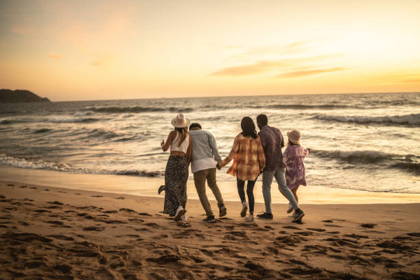 istock Friends walking holding hands at the beach 1442735368