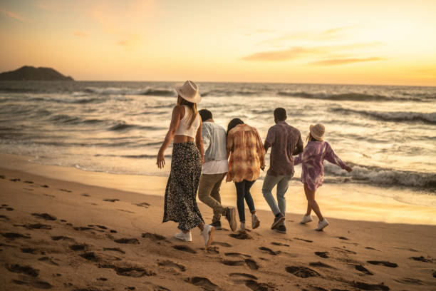 istock Friends walking holding hands at the beach 1442735371